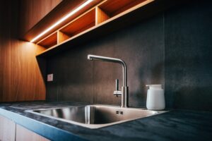 water,faucet,and,metallic,sink,in,modern,sleek,kitchen,with